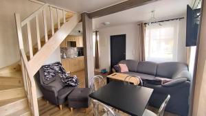 een woonkamer met een bank en een tafel bij OZZI LAND Resort in Sobącz