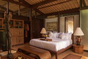 um quarto com uma cama e dois candeeiros em Dua Dari, a Residence by Hadiprana em Ubud