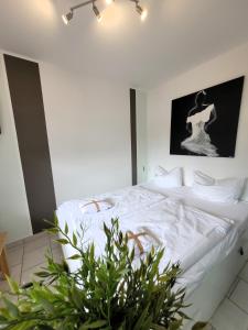 ヴィンターベルクにあるWinterberg Appartement 21074のベッドルーム1室(白いシーツと植物付)