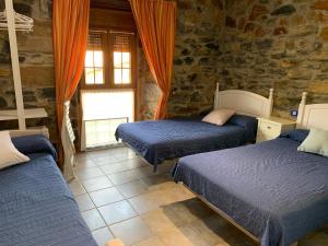 1 dormitorio con 3 camas y ventana en Agroturismo Gure Naia, en Carranza