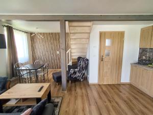 a living room with a table and a dining room at OZZI LAND Resort in Sobącz
