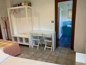 a bedroom with a table and two chairs and a bathroom at Agroturismo Gure Naia in Carranza