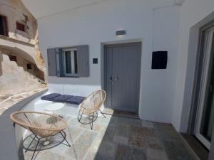 a room with a table and chairs and a door at Koutsounos in Kithnos