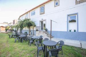 uma fila de mesas e cadeiras em frente a um edifício em Albergue A Fabrica em Santiago de Compostela