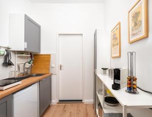 a kitchen with white cabinets and a white door at 2-Room Apartment near Messe and Lietzensee in Berlin