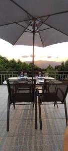 - une table et un parasol sur la terrasse dans l'établissement Refúgio da Chiquinha, à Vieira do Minho