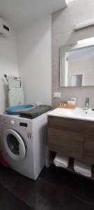 ein Badezimmer mit einer Waschmaschine und einem Waschbecken in der Unterkunft Palms House in Rom