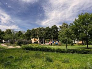 a park with a playground with trees and a grass field at Home and Sea in Gdańsk