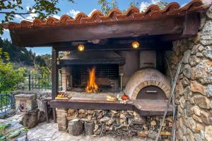 a stone pizza oven with a fire in it at Ifigenia Theriso Village in Thérison