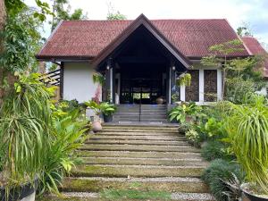 uma casa com uma escada que leva à porta da frente em Calape Forest Resort em Calape