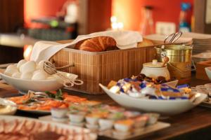 ヒルデスハイムにある1891 ヒルデスハイム ブティックホテルの卵、パン、皿を盛ったテーブル