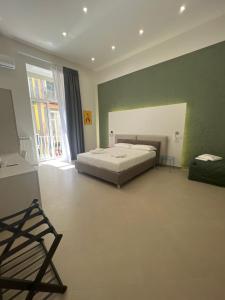 Un dormitorio con una cama y una ventana grande. en Dimora Chiaia 209, en Nápoles