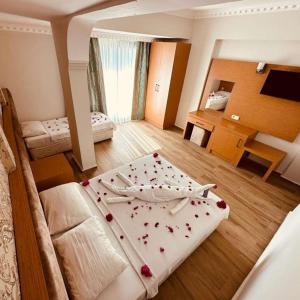 a large room with two beds and a desk at Britannia Hotel Village in Kemer