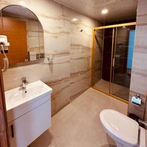 a bathroom with a sink and a shower and a toilet at Britannia Hotel Village in Kemer