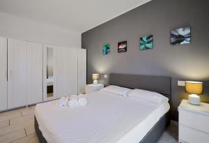 a bedroom with a large white bed with two towels on it at Xenia Apartments - New and Bright Urban Housing in Milan