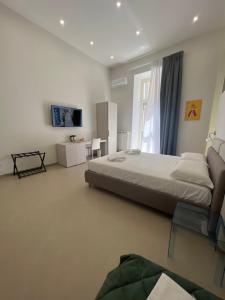 Un dormitorio con una cama grande y una ventana. en Dimora Chiaia 209, en Nápoles