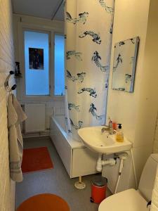 a bathroom with a sink and a shower curtain at Lovely Apartment in Gothenburg