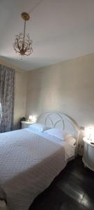ein Schlafzimmer mit einem großen weißen Bett und einem Kronleuchter in der Unterkunft Palms House in Rom