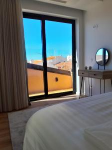 a bedroom with a large window with a view at Beachfront Apartment in Vila Praia de Âncora