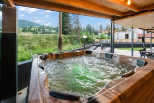 a hot tub in the middle of a patio at Transylvania House in Arieşeni