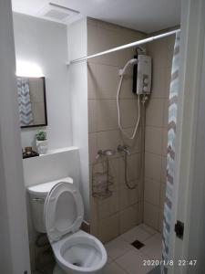 ein Bad mit einer Dusche, einem WC und einer Dusche in der Unterkunft Pine Suites JR Studio, a Serene & Relaxing place in Tagaytay