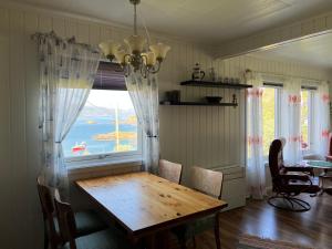 een eetkamer met een houten tafel en een raam bij Bestefarhuset in Hakkstabben