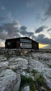 a building sitting on top of a field with rocks at Sevan - Tsovazard Beach House in Tsovazard