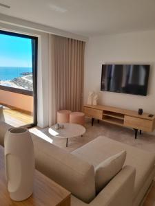 a living room with a large flat screen tv at Beachfront Apartment in Vila Praia de Âncora