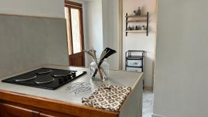 a kitchen counter with a stove and a vase with utensils at Casa Ghjuvanna 2 chambres in Prunelli-di-Fiumorbo