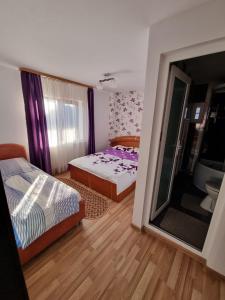 Habitación pequeña con 2 camas y baño. en Pensiunea Ileana en Novaci-Străini