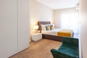 1 dormitorio con 1 cama y 1 silla en Liberdade Home Stay - Minho's Guest en Braga