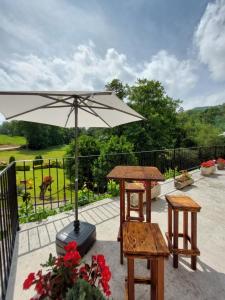 un patio avec une table et un parasol dans l'établissement Vivienda Rural - Apartamentos La Cueva - Hornedo, à Entrambasaguas