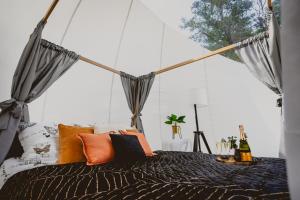 a bedroom with a bed with orange pillows at Golden Glamping nad Narwią in Lubiel Stary