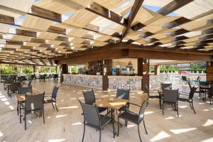 a restaurant with tables and chairs under a wooden ceiling at Kaya Belek in Belek