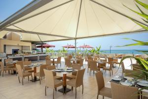a restaurant with tables and chairs with a view of the ocean at Kaya Belek in Belek