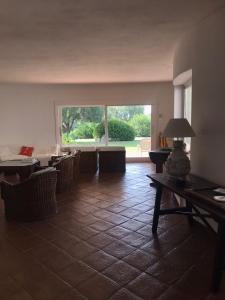 een woonkamer met een tafel en stoelen en een groot raam bij Villa Degli Olivi in Pula +25 foto's