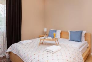 sypialnia z łóżkiem z niebieskimi poduszkami i stołem w obiekcie Orlowo Park - Spacious Apartment with Winter Garden by Renters w mieście Gdynia