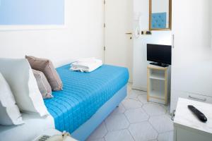 1 dormitorio con 1 cama con sábanas azules y TV en Hotel Italia en Rímini