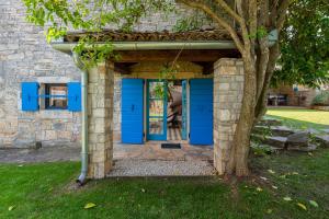 una puerta azul en un edificio de piedra con un árbol en Villa Lucija en Rovinjsko Selo