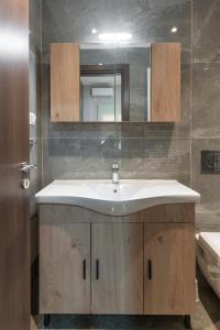 een badkamer met een wastafel en een spiegel bij Cosy 2BR Apartment next to Bars & Restaurants in Athene