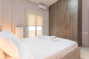 een slaapkamer met een groot wit bed en handdoeken bij Cosy 2BR Apartment next to Bars & Restaurants in Athene