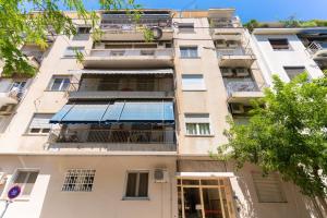 een hoog appartementencomplex met een blauwe luifel bij Cosy 2BR Apartment next to Bars & Restaurants in Athene