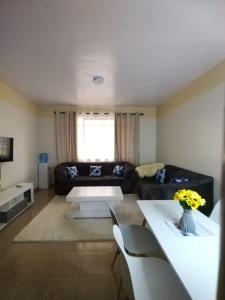 sala de estar con sofá y mesa en Grey Homes, 2 bedroom apartments along mombasa road, near JKIA & SGR Nairobi, en Syokimau
