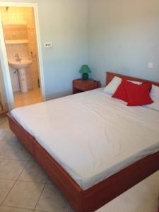 een slaapkamer met een groot bed met rode kussens bij Villa Marija in Smokvica