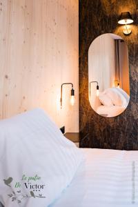 - une chambre avec un lit blanc et un miroir dans l'établissement Hôtel Le Patio de Victor, Lorient, à Lorient