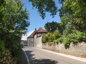 eine leere Straße mit einer Steinmauer und einem Haus in der Unterkunft Le Clos- Le Pavillon in Lombard