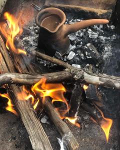 einen Topf, der auf einem Feuer mit Flammen sitzt in der Unterkunft Warm House in Kazbegi