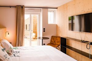 a bedroom with a bed and a table and a chair at Hôtel Le Patio de Victor, Lorient in Lorient