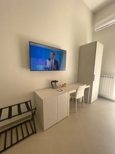 a living room with a tv on the wall at Dimora Chiaia 209 in Naples