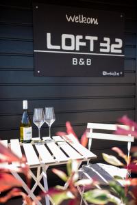 a table with two glasses and a bottle of wine at Loft 32 in Winsum